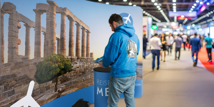 Ein Mann steht vor einer Zipper Banner Wand Straight auf einer Messe