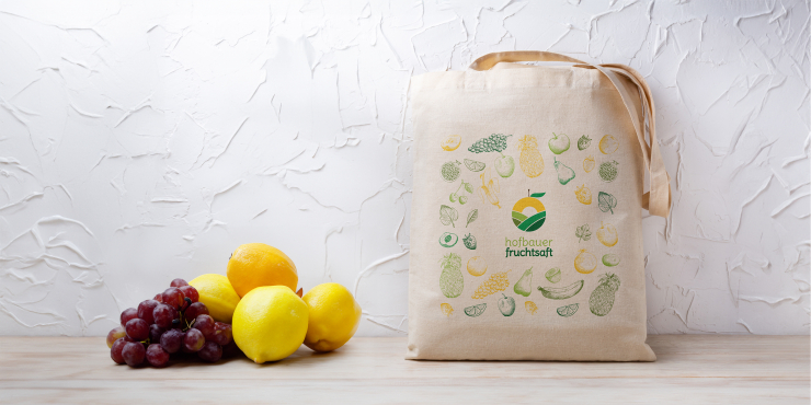 Individuell bedruckte Stofftasche mit grünen Print neben Obst