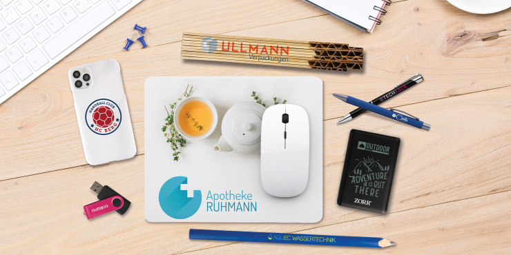 Diverse bedruckte Give-aways auf einem Schreibtisch 