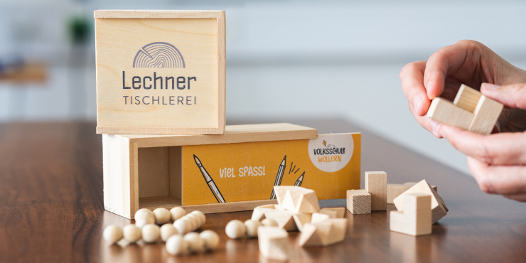 Eine Person baut ein individuell bedruckbares Geschicklichkeitsspiel aus dem Spieleset zusammen