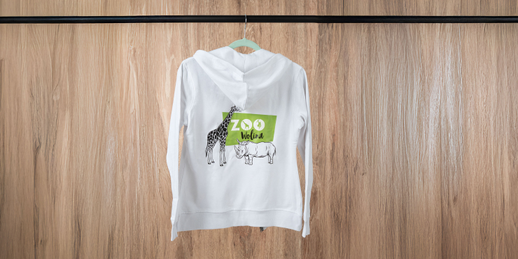 Weißer Zip-Hoodie mit Logo am Rücken, der auf einer schwarzen Stange hängt