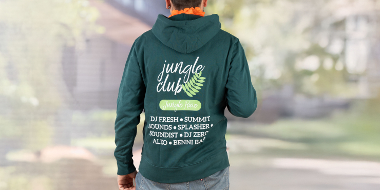 Männliche Person trägt einen dunkelgrünen Stanley/Stella-Zip-Hoodie, der auf der Rückseite bedruckt ist