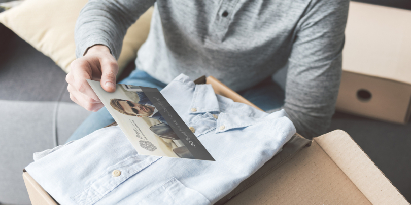 Jemand packt Pakete mit bedruckten Postkarten ein
