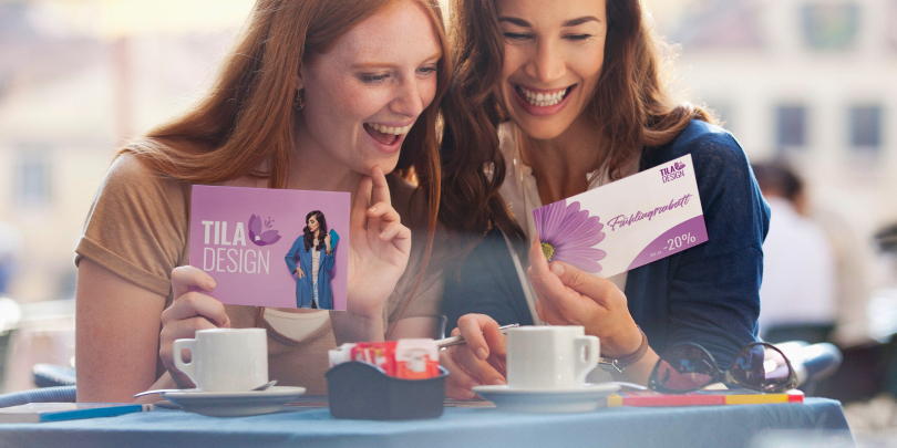 zwei Frauen schauen sich eine bedruckte Postkarte an