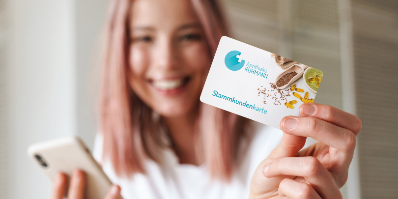 Frau hält eine personalisierte Karte in die Kamera