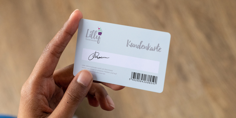 Jemand hält bedruckte Plastikkarte mit Unterschriftsfeld