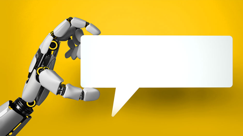 Eine Roboter-Hand hält eine Sprechblase in der Hand.