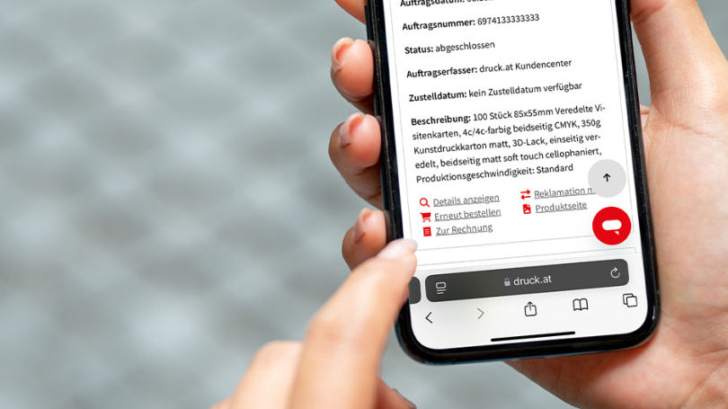 Eine Hand hält ein Handy, die andere tippt am Bildschirm.