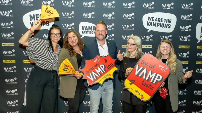 Gruppenbild vom VAMP-Award auf dem mehrere Personen Schilder und Klatschfächer halten
